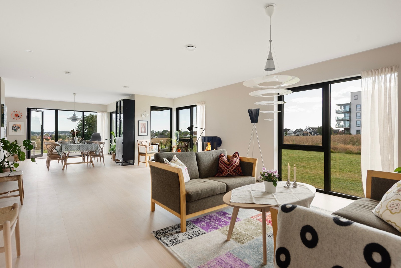 Romslig og lys stue med store vindusflater som slipper inn rikelig med naturlig lys og skaper en åpen atmosfære Galleribilde