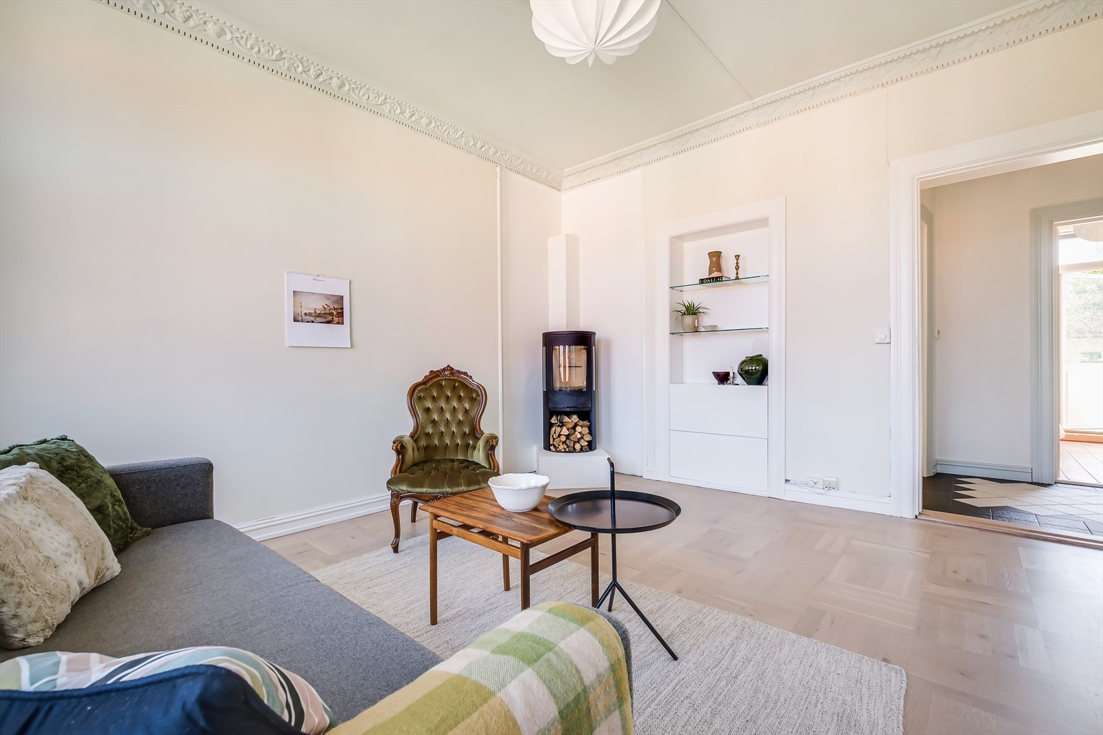 Midtpunktet i rommet er en stilfull vedovn som ikke bare gir ekstra varme, men også skaper en lun og koselig atmosfære Galleribilde