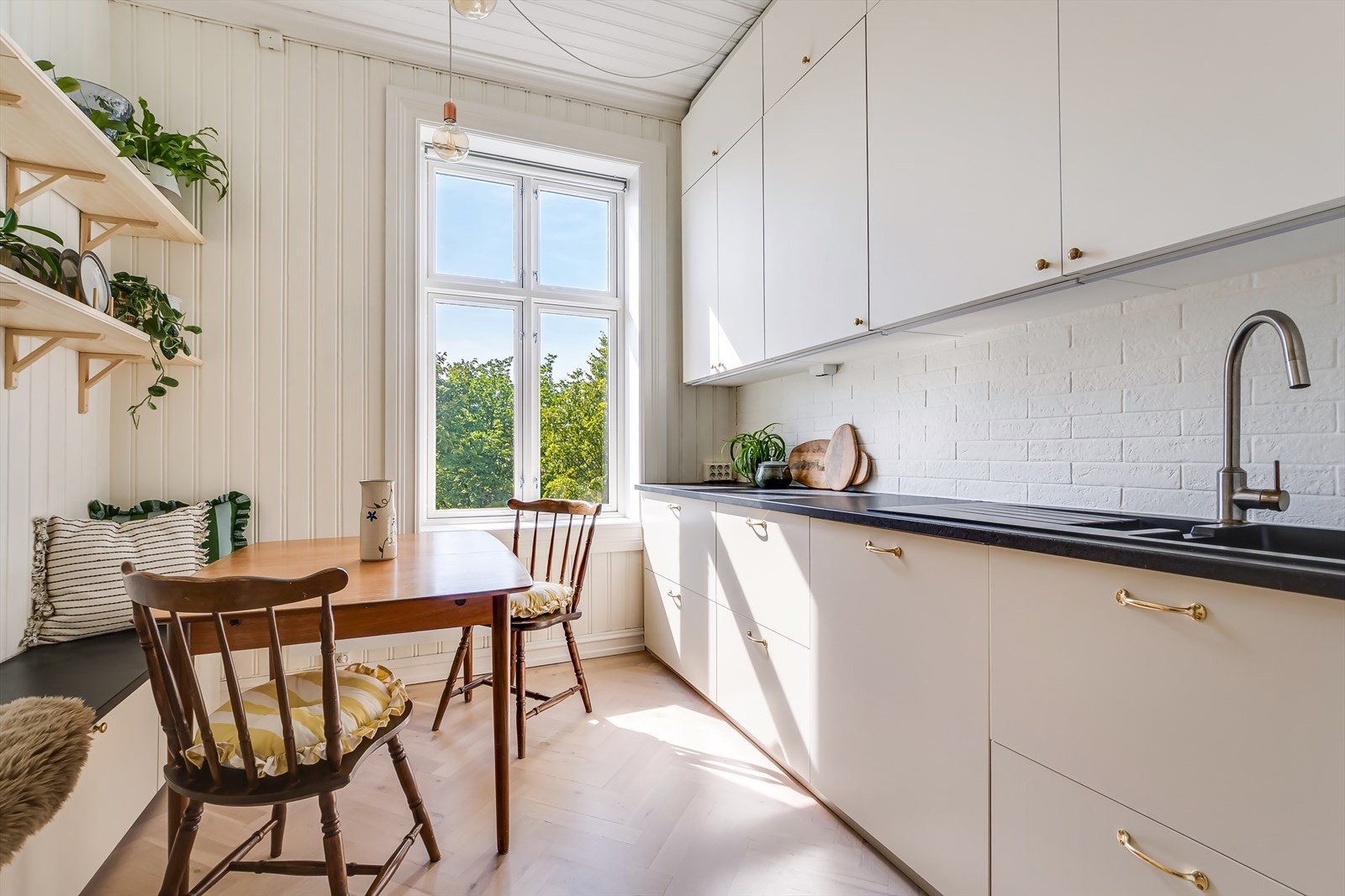 Det stilrene kjøkkenet er fra 2016 (i henhold til tidligere salgsoppgave) og har lyse fronter, fliser på bakvegg og laminert benkeplate Galleribilde