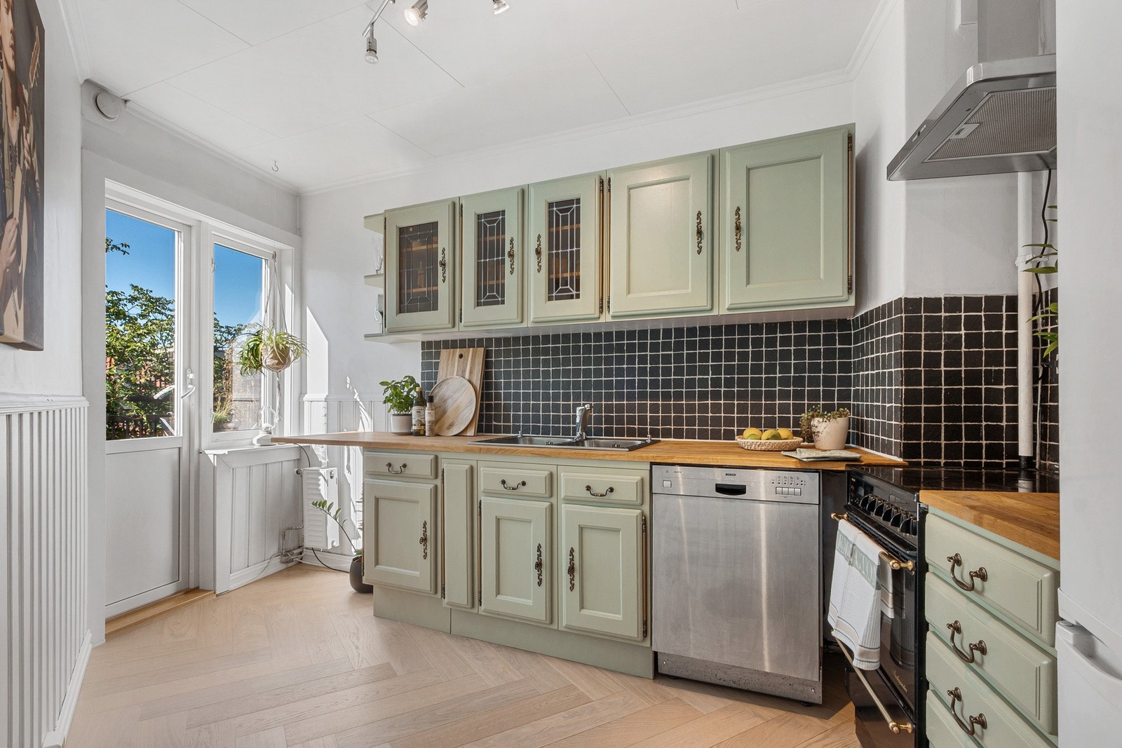 Innbydende kjøkken med glatte fronter og heltre benkeplate som gir en lun og tidløs atmosfære. Galleribilde