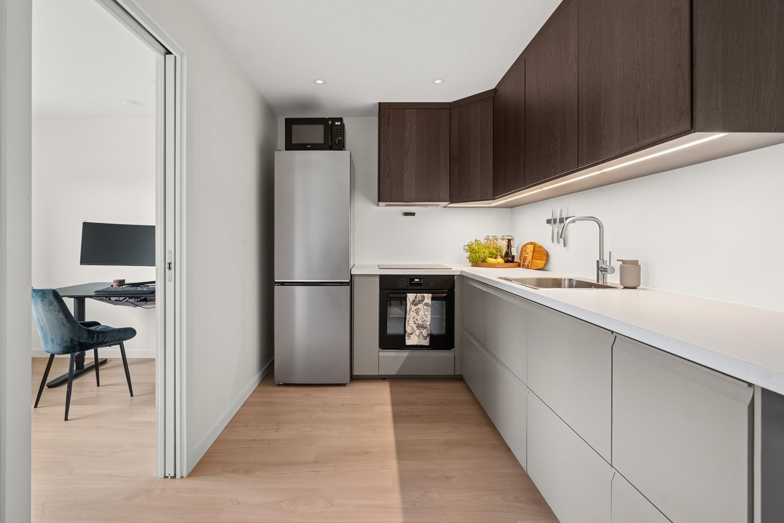 Kjøkkenet har en innredning med glatte fronter og laminat benkeplate. Kjøkkenet er videre utstyrt med kjøl/fryseskap, oppvaskmaskin, komfyr, platetopp og avtrekk. Galleribilde