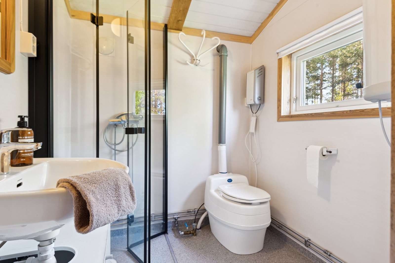 Bad fra 2022 med dusjvegger, servant og separett toalett, . Belegg på gulvet og plater på vegger Galleribilde