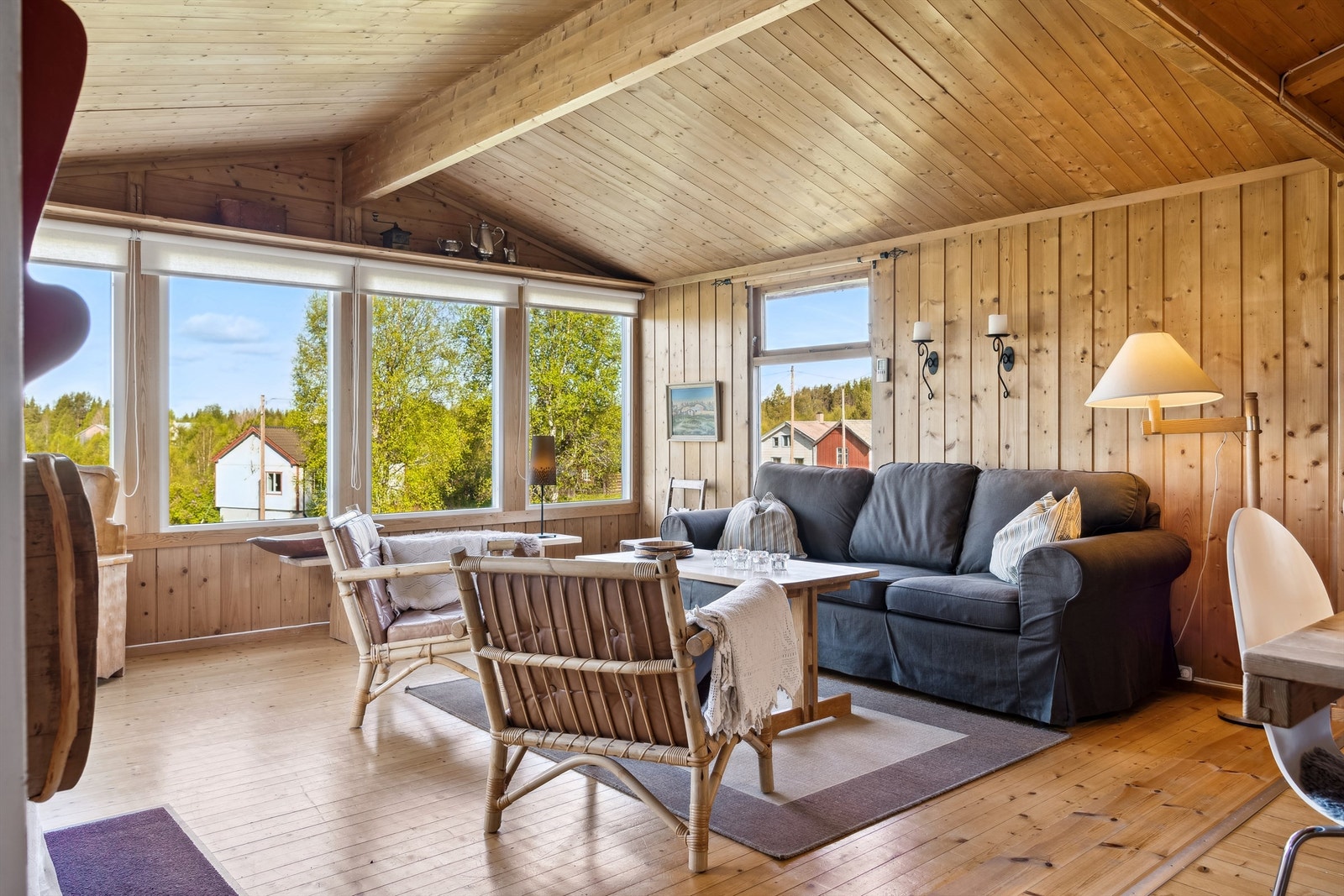 Stua har en gjennomført hyttestil med overflater i tre og god takhøyde Galleribilde