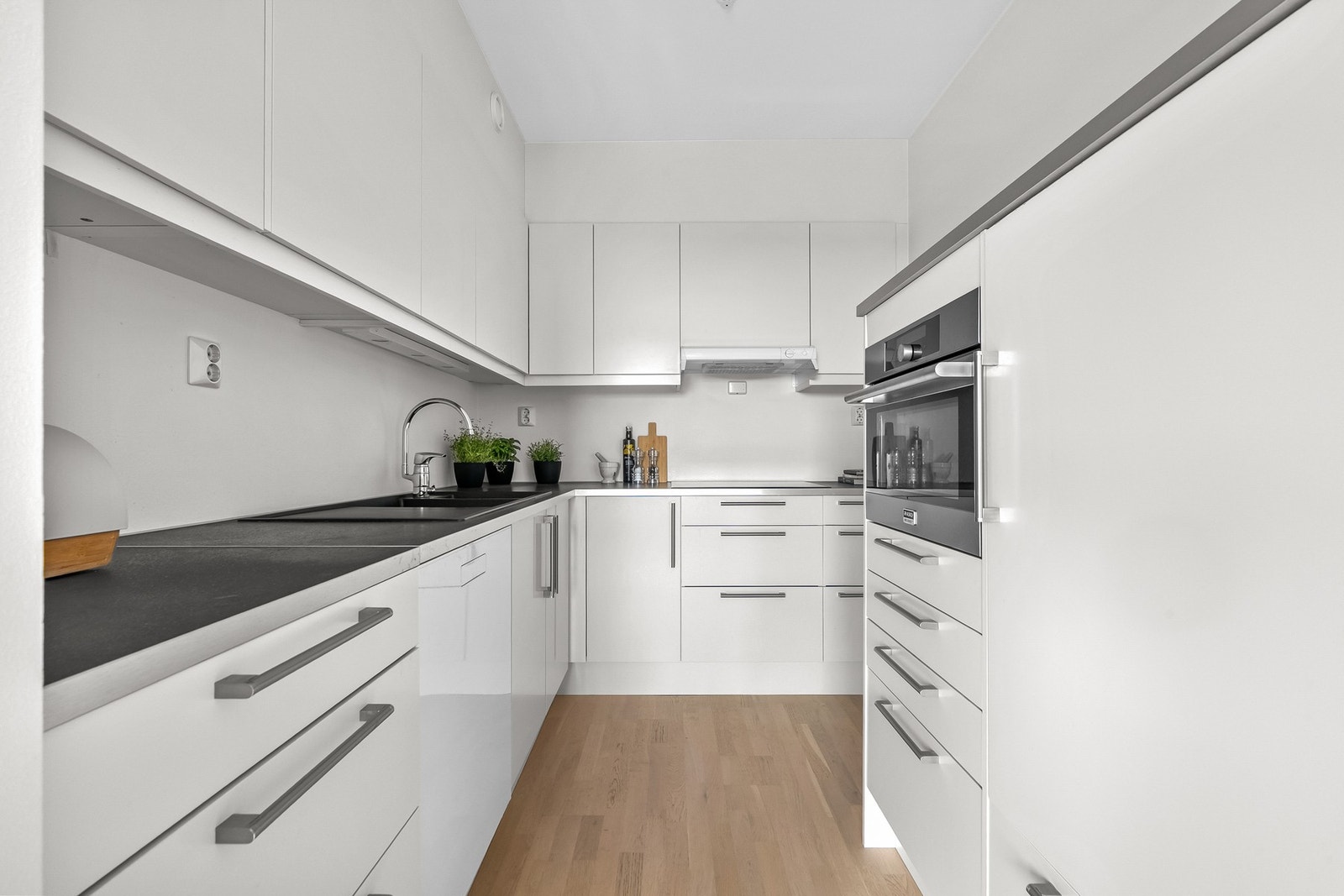 Det er laminat benkeplate, nedfelt kvartskompositt Blanco kum og ventilator tilsluttet kanal/ventilasjonssystemet. Det er ettermontert en "kjøkkenøy" hvor kjøleskap og stekeovn med kombinert mikrofunksjon er plassert. Galleribilde
