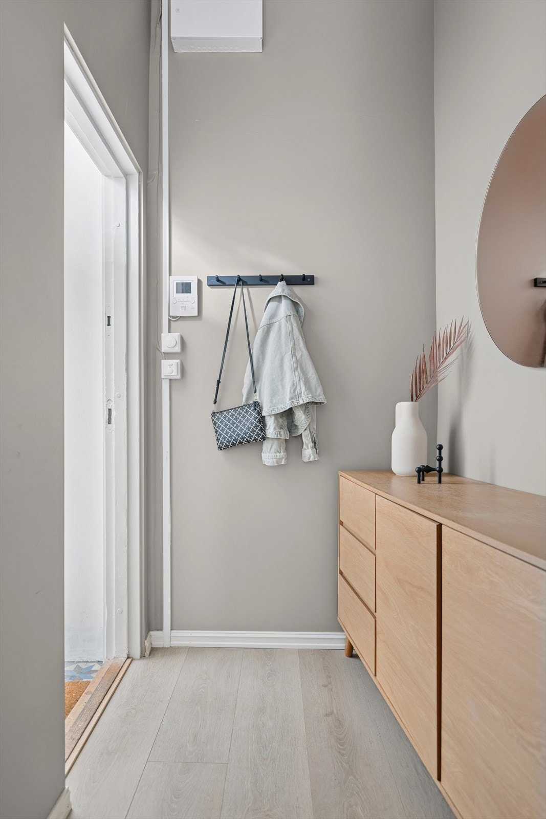 Lys og innbydende entrè med plass til å sette fra seg sko og henge yttertøy. Her er det også rom for kommode eller skap, og de lyse overflatene gir et hyggelig førsteinntrykk. Galleribilde