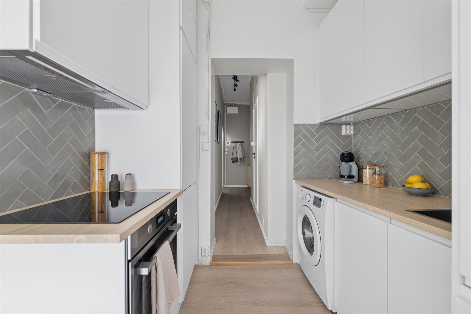 IKEA kjøkkeninnredning med slette, lakkerte fronter og laminat benkeplate med delikat flislagt vegg i grønntoner. Galleribilde