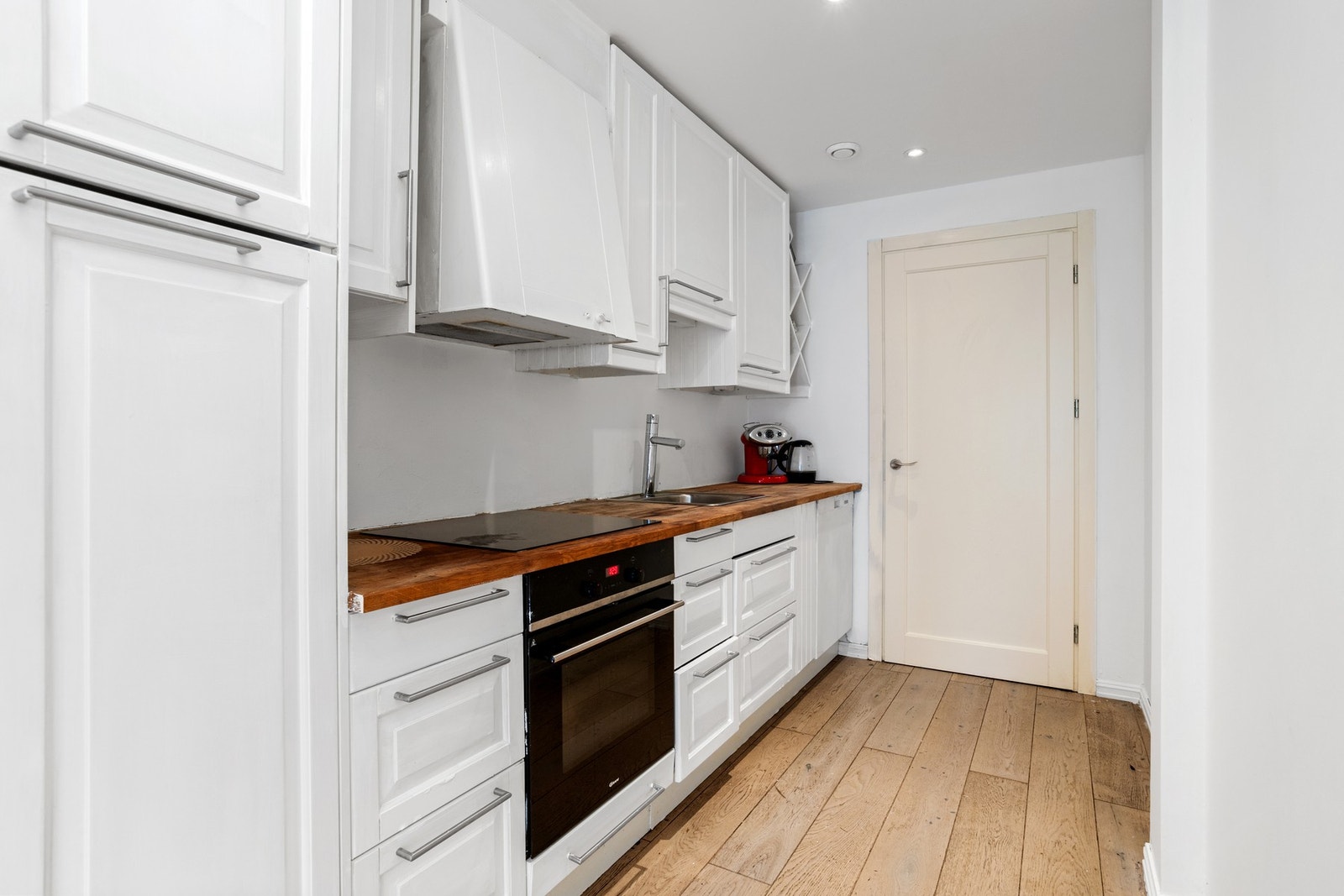 Kjøkkenet har klassiske hvite, profilerte fronter og laminat benkeplater. Galleribilde