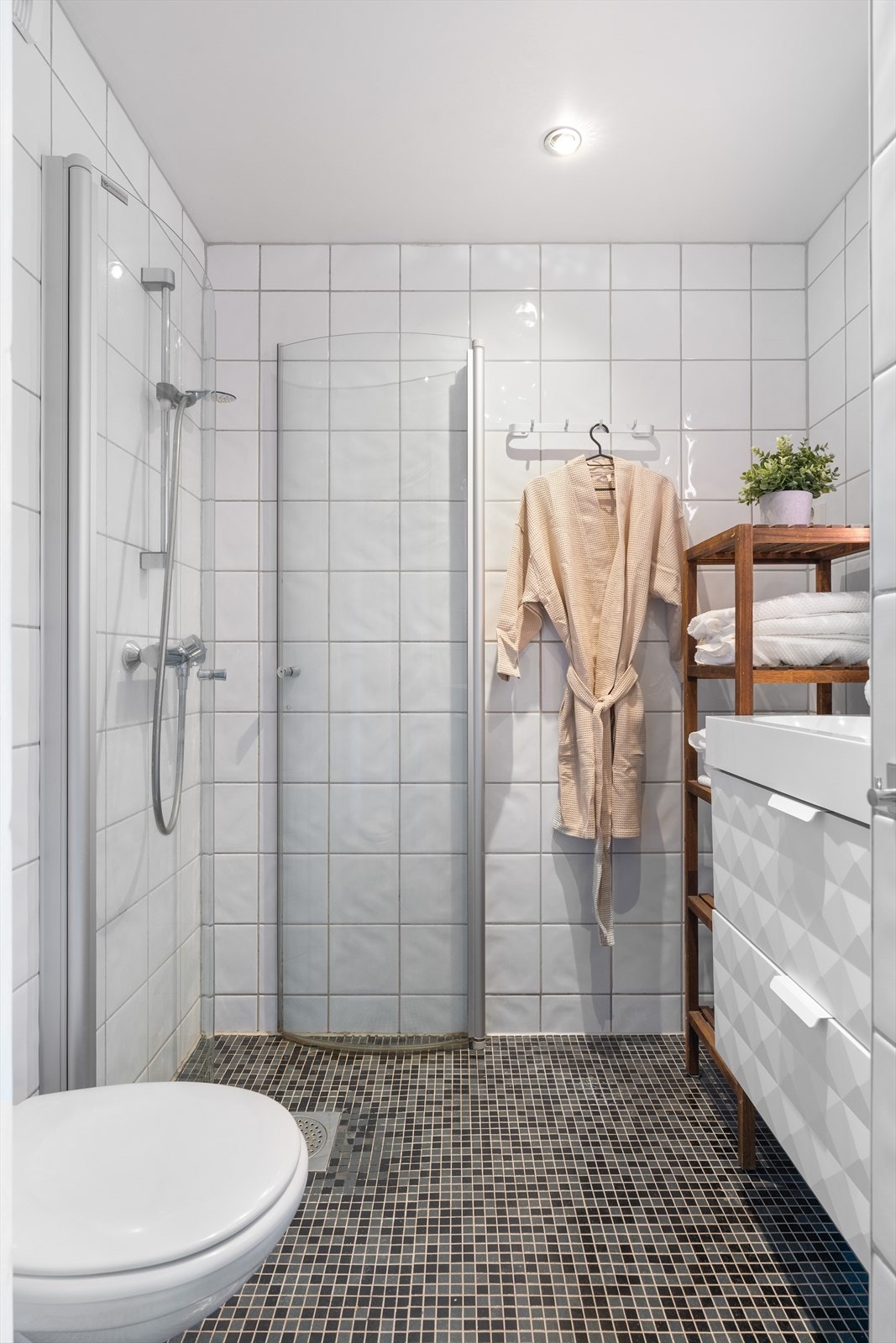 Badet holder et lyst og tidløst preg med sine flislagte overflater. Galleribilde