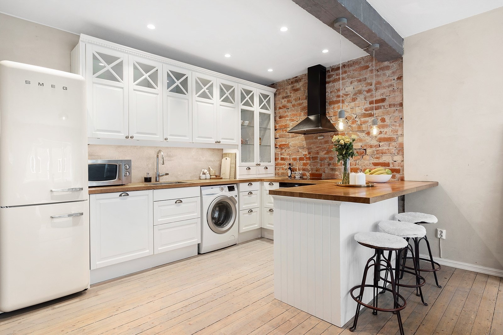 Kjøkkenet er innredet med
profilerte fronter, frittstående kjøleskap,
integrert oppvaskmaskin, induksjonstopp og stekeovn. Galleribilde