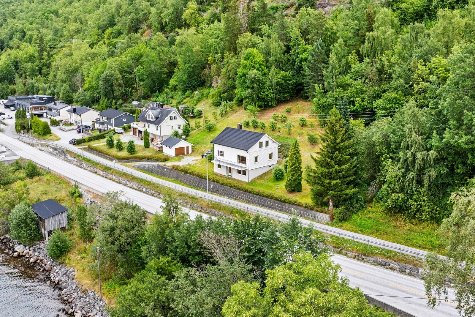 Den store tomta er på over tre mål der deler av tomta er naturtomt samt plenareal med variert beplantning og grusa parkeringsområde. Galleribilde