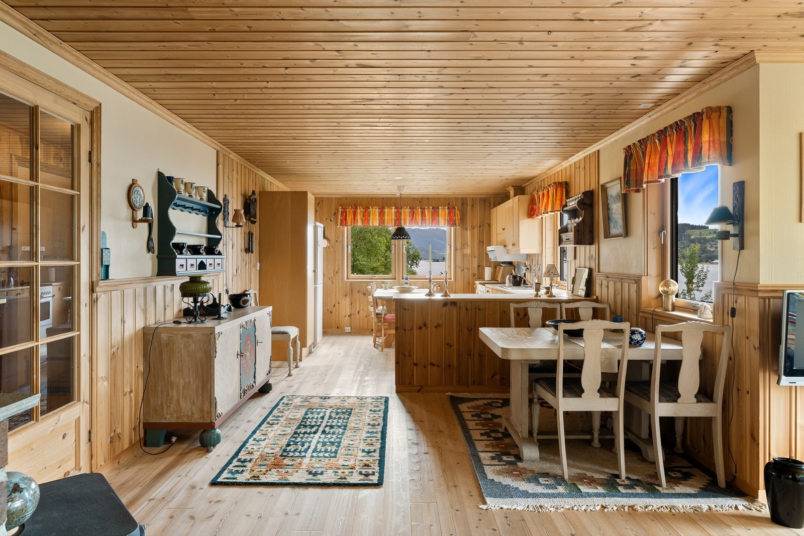 Kjøkkenet er romslig, med god plass til oppbevaring og et stort spisebord hvor måltider kan nytes med utsikt mot sjøen. Galleribilde