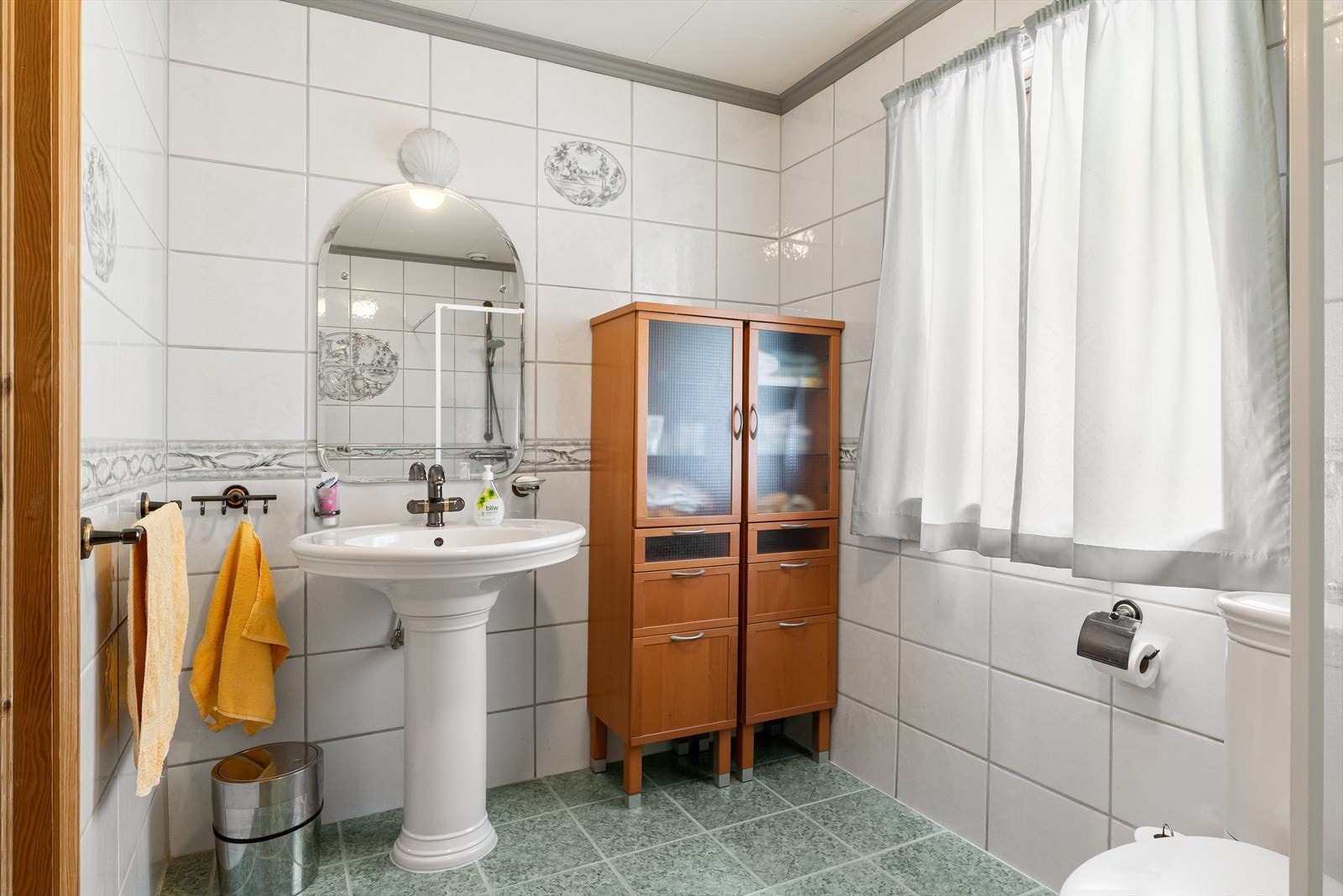 Boligens bad er flislagt og er innredet med dusjhjørne, toalett og servant. Galleribilde