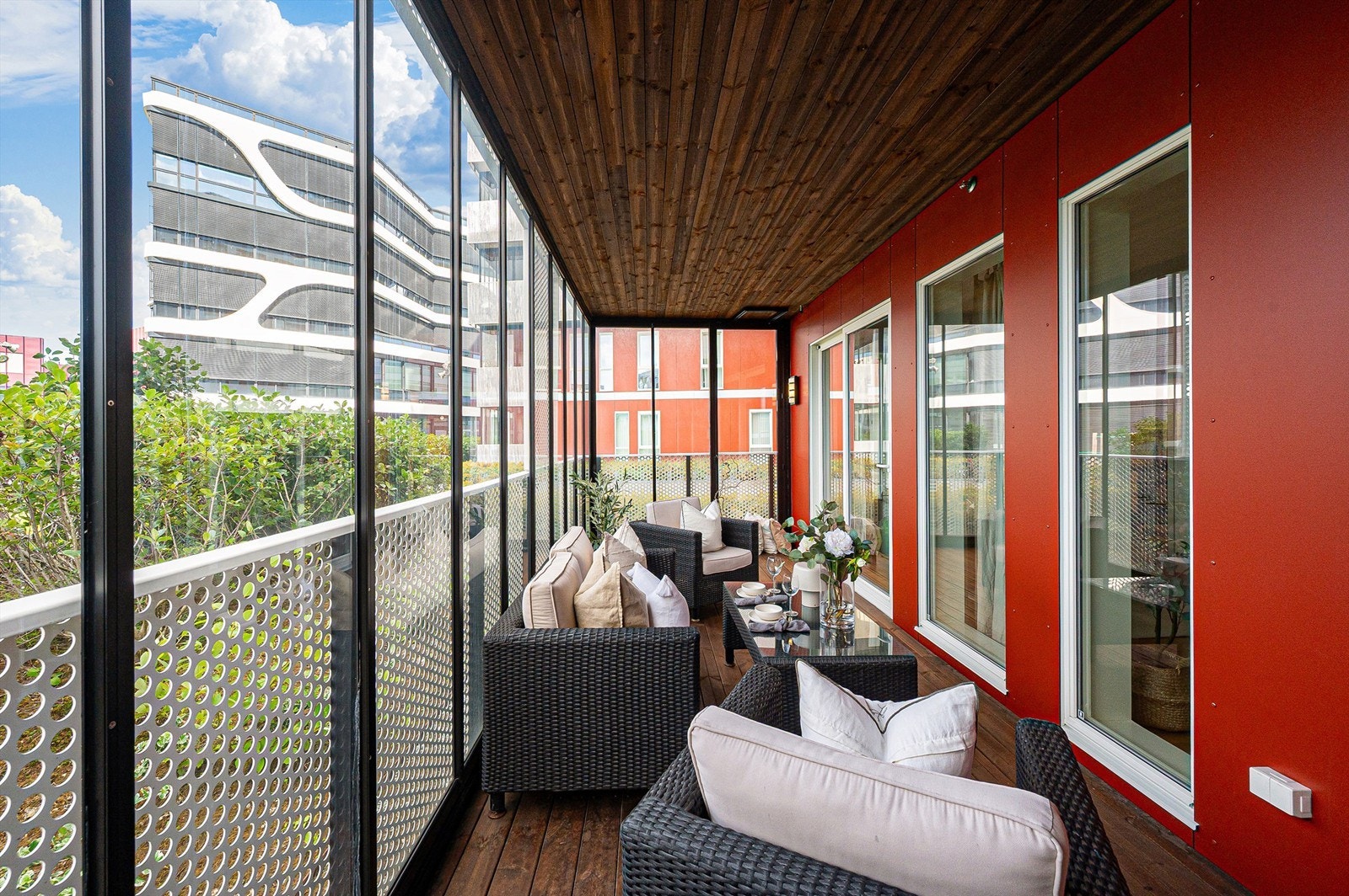 Den romslige og innglassede balkongen gir en ekstra stue året rundt, perfekt for både avslapning og sosiale sammenkomster. Galleribilde