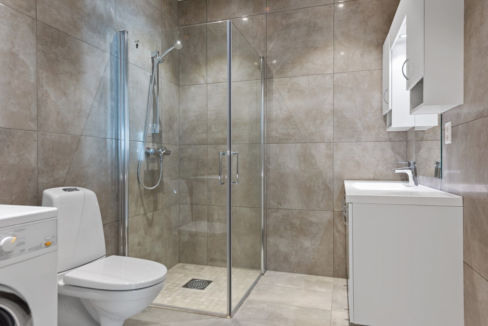 Delikat flislagt baderom med elektriske varmekabler i gulv og downlights i himling. Galleribilde