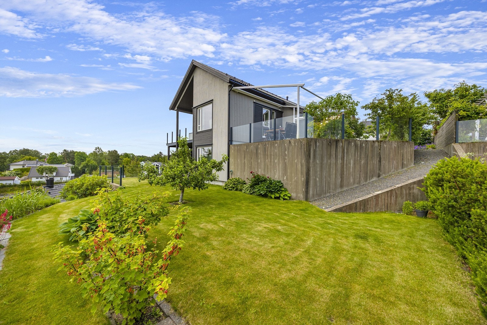 Det er overbygd terrasser på fremsiden og stor terrasse i betong på baksiden. Galleribilde