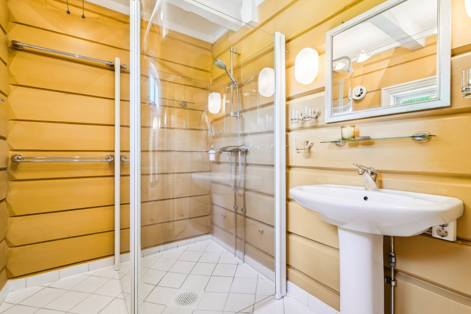 Badet er utstyrt med servant, speil og vegghylle og belysning montert på veggen og ved taket. Dusjhjørne med glassdører og vegghengt armatur. Det er montert ny el-vifte på badet. Galleribilde