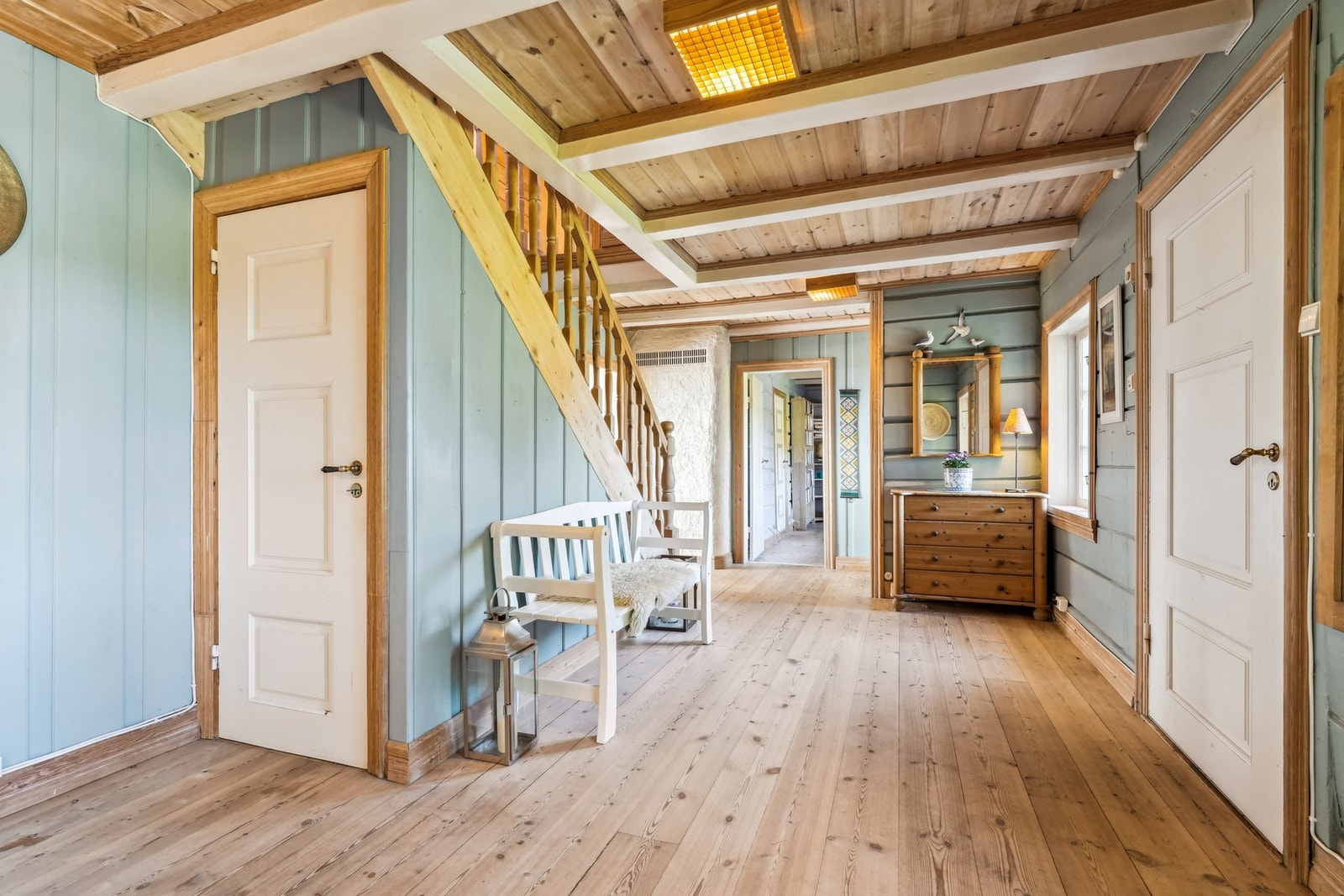 Fine detaljer med heltre furugulv og malte tømmervegger. Dør under trappen er ned til kjelleren. Galleribilde