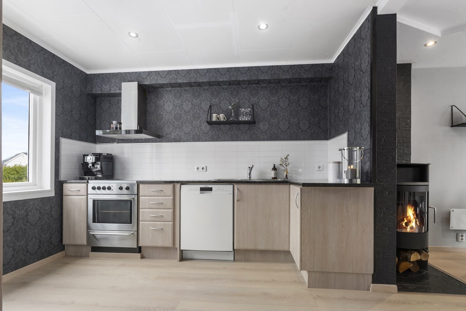 Kjøkkeninnredning med glatte folierte fronter, med benkeplate av laminat med imitasjon av stein. Galleribilde