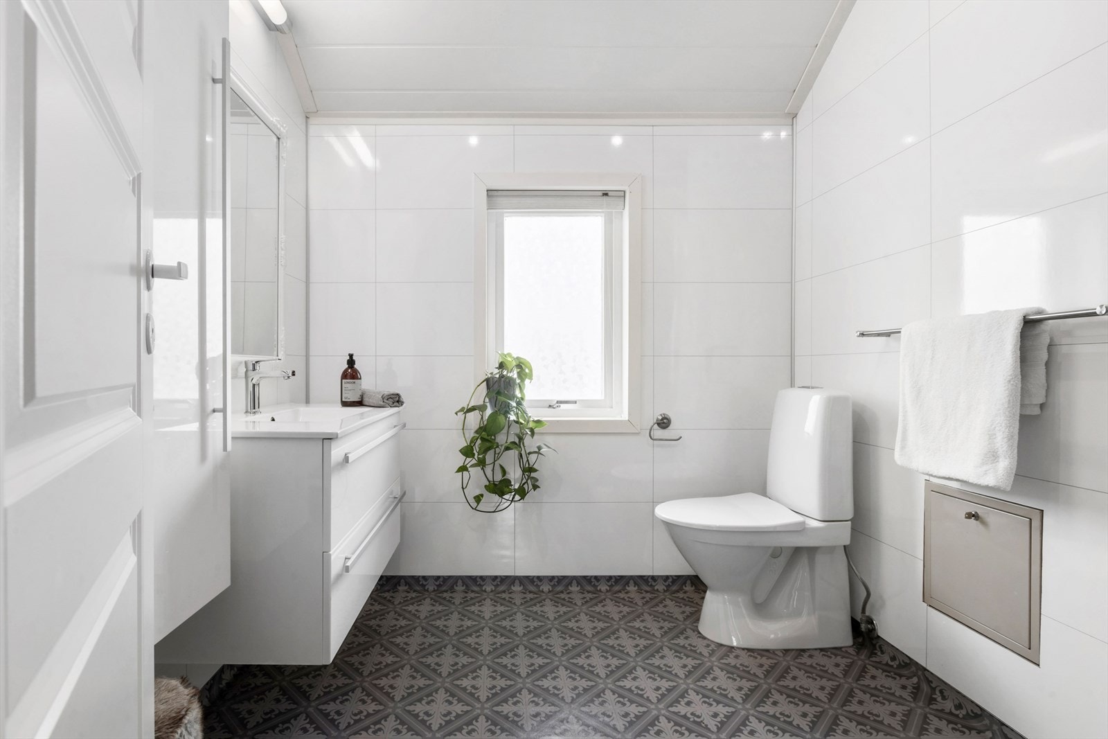 Bad innredet med rør-i-rør fordelerskap, wc, dusjnisje med buede glassdører og vegghengt baderomsinnredning med heldekkende servantplate, samt vegghengt høyskap for ekstra oppbevaring. Galleribilde