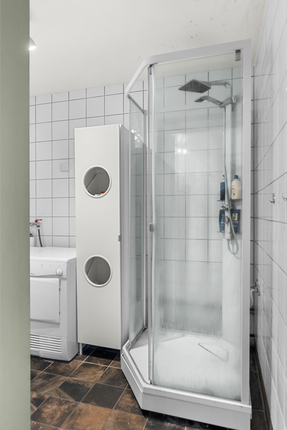 Badet er utstyrt med duskabinett, veggmontert servantinnredning og opplegg for vaskemaskin Galleribilde