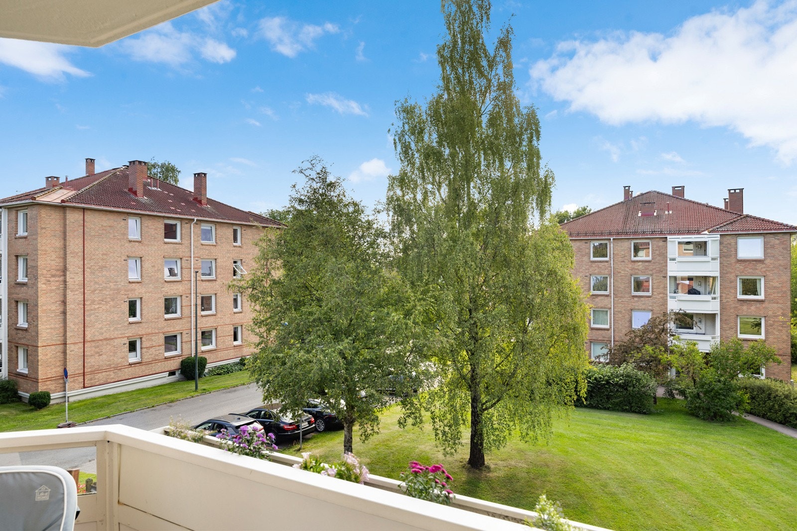 Fra balkongen er det flott utsyn over nabolaget med de store og pent opparbeidet grøntområdene til borettslaget. Galleribilde