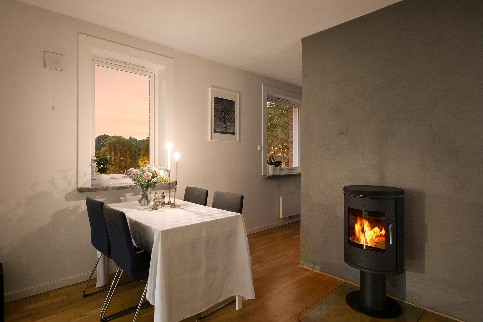 Hyggelig spiseplass ved vindu og peisovn med glassfelt Galleribilde