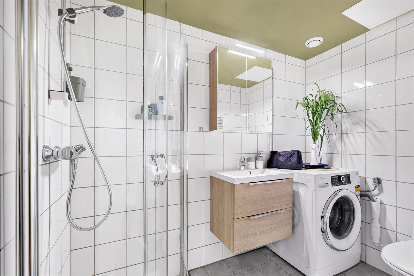 Lyst, delikat og flislagt baderom med plass til alt man trenger Galleribilde