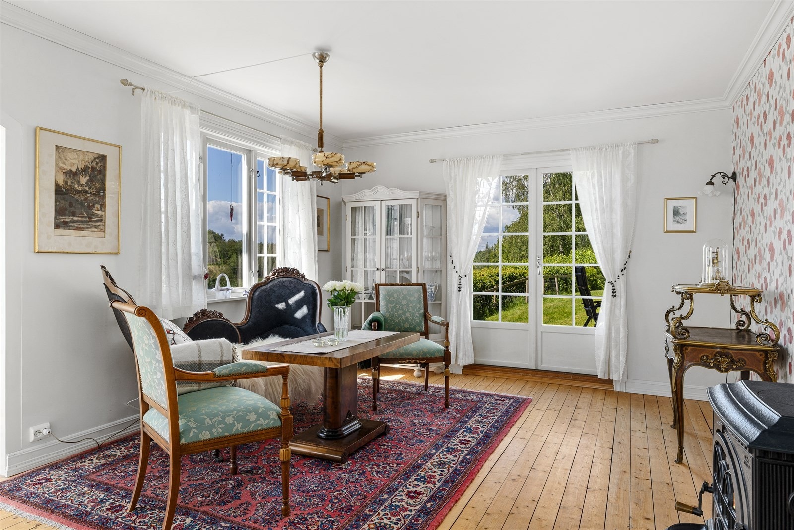 Lys stue med utgang til terrasse og grønne omgivelser Galleribilde