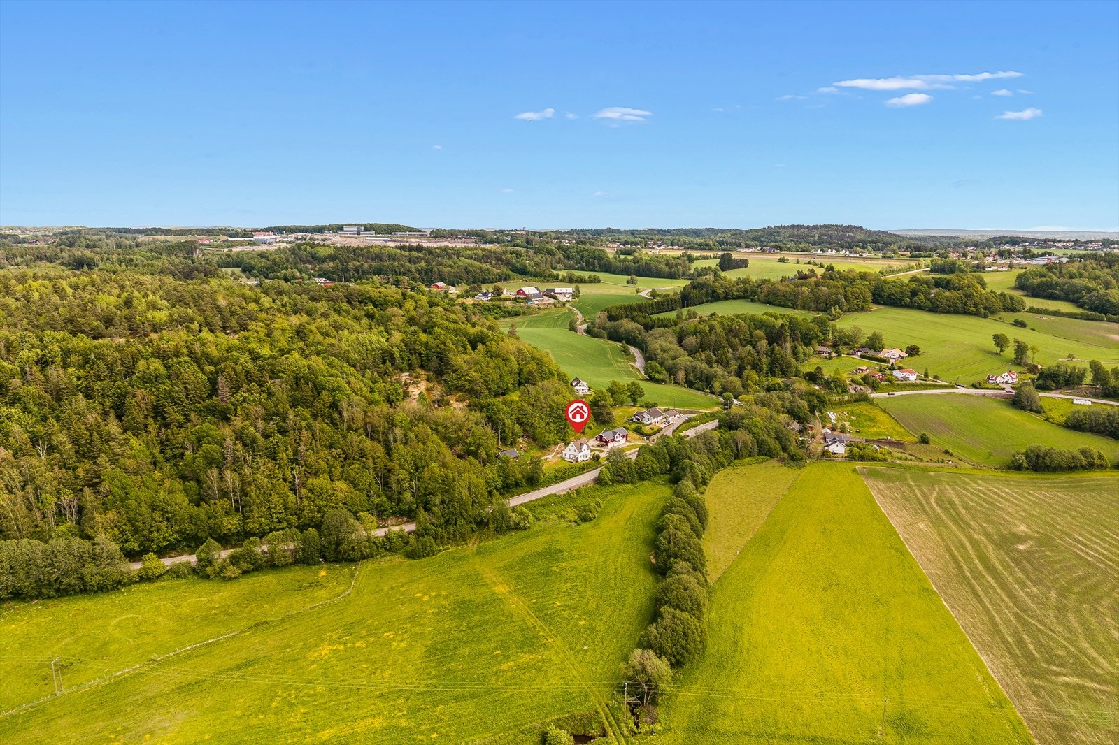 Luftbilde med retning mot bebyggelse og vann - illustrerer landlig plassering Galleribilde
