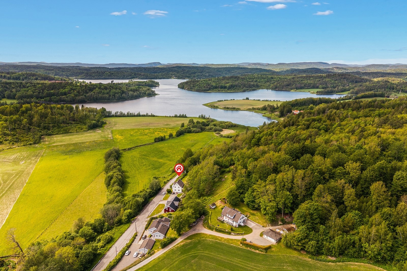 Flyfoto som viser eiendommens helhetlige omfang - boligen, låven og de store teigene Galleribilde