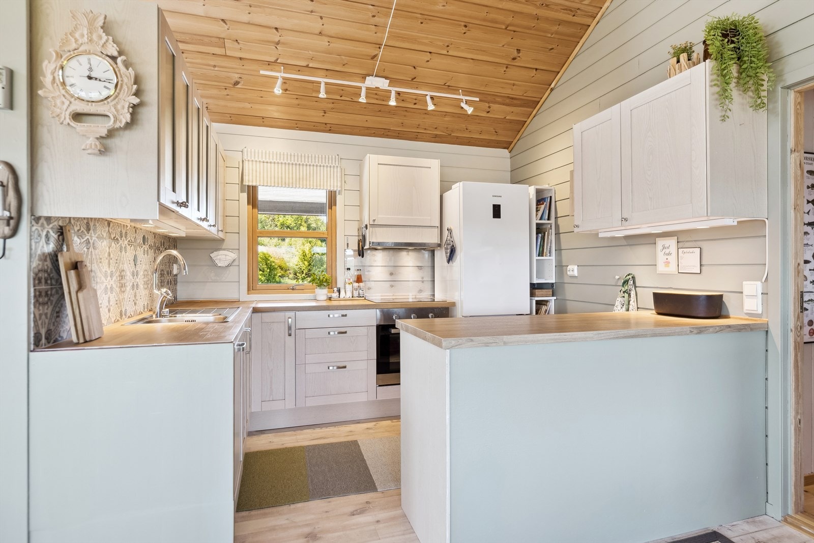 Kjøkken i lys utførelse med oppbevaring i over- og underskap. Hvitevarer medfølger handelen. Galleribilde