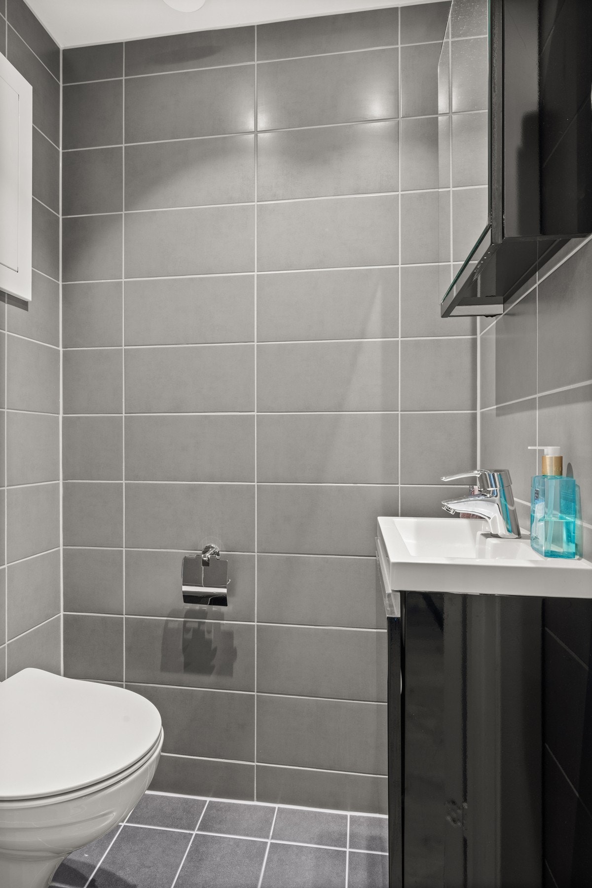 Nytt toalettrom fra 2021 som også er pusset opp i regi av brl i 2021. Varmekabler og downlights. Veggmontert klosett. Servantskap og heldekkende servant med speilskap over. Galleribilde