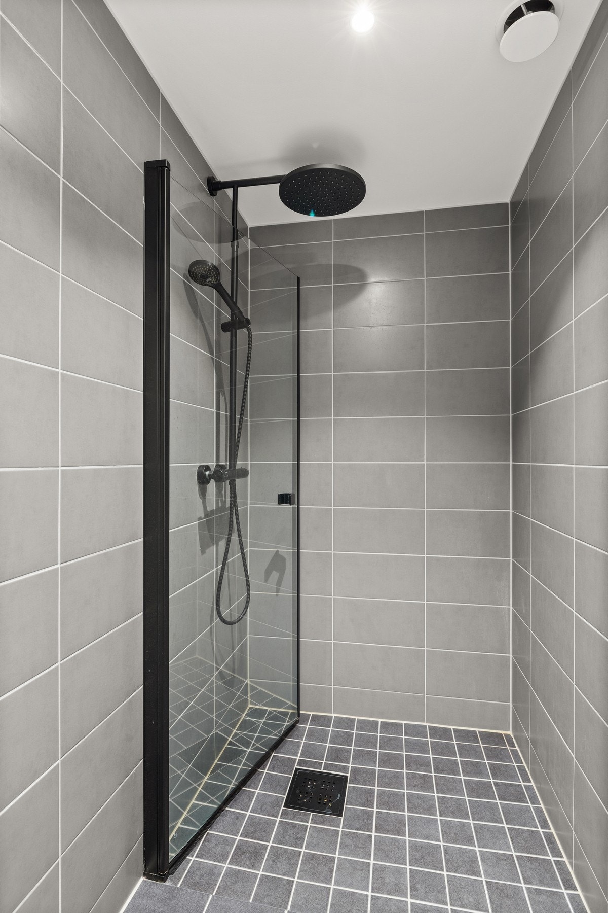 Dusjhjørne med svingdør og regnfallsdusj. Galleribilde