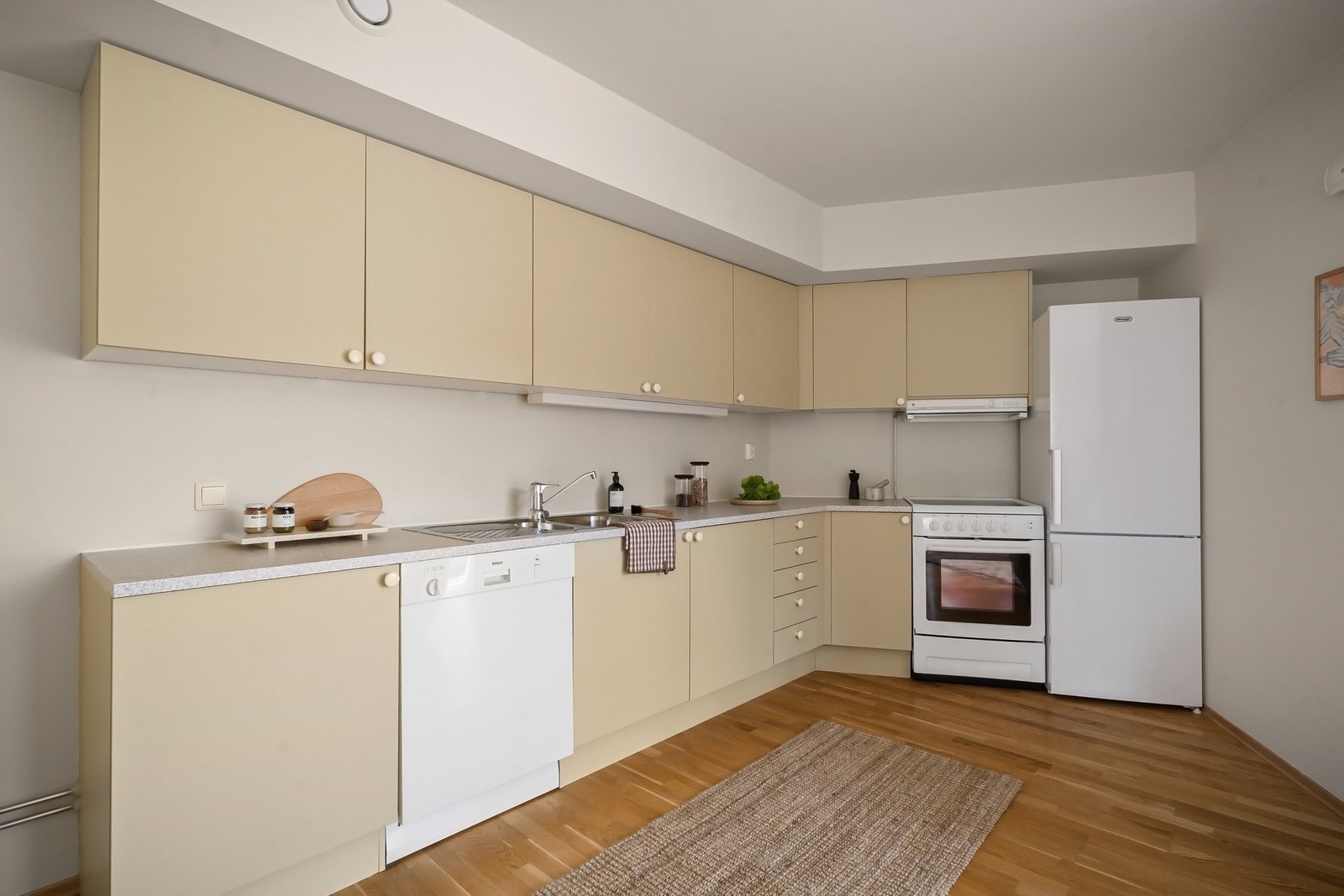 Innredning med malte fronter og laminat benkeplate. Nisjer for oppvaskmaskin, komfyr og kjøleskap. Galleribilde