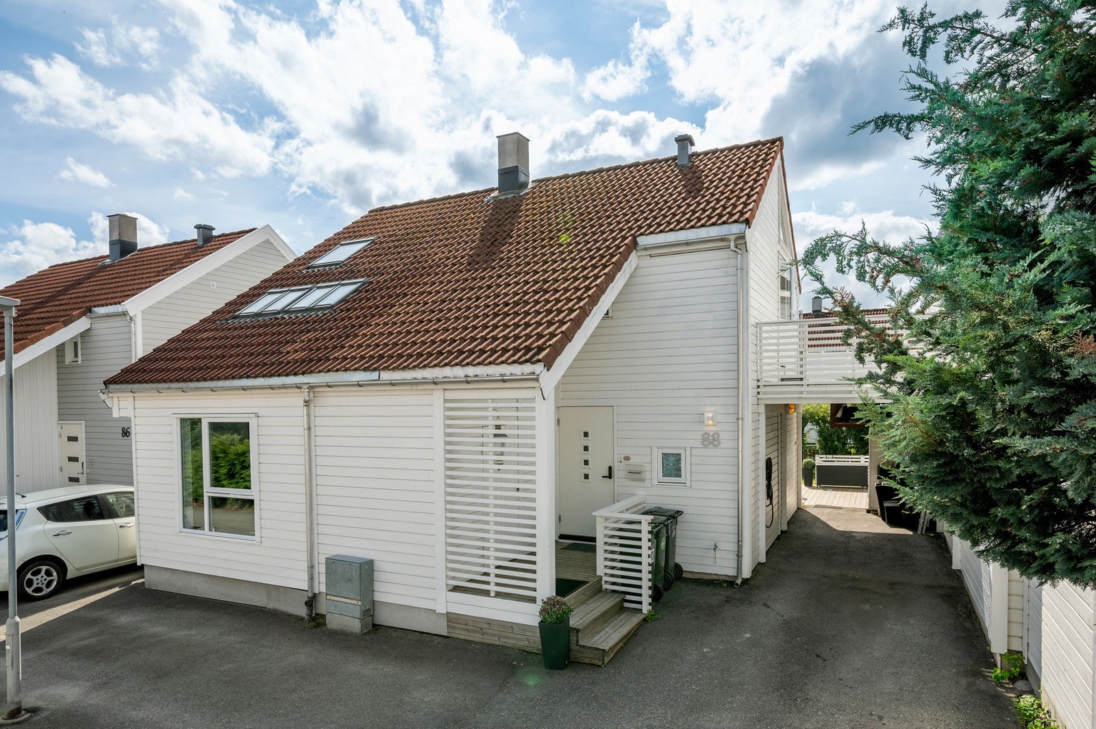 Innbydende gårdsplass med gode parkeringsmuligheter utenfor døra. Den ene terrassen fungerer som tak til carport Galleribilde