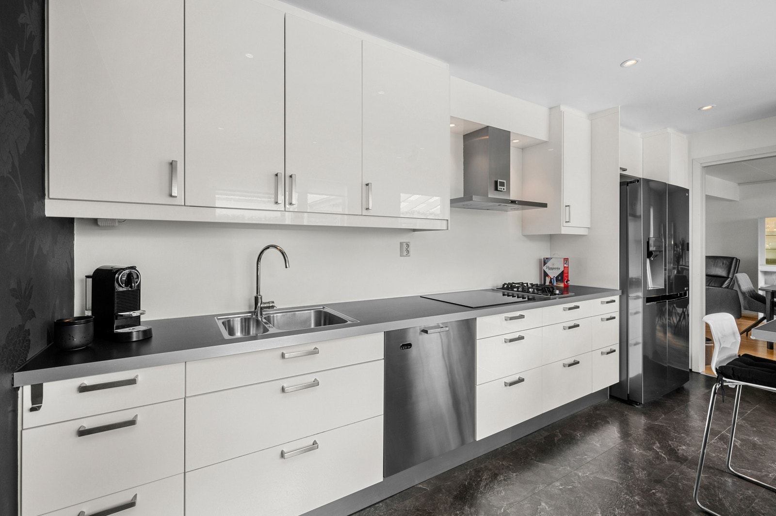 Moderne kjøkken med rikelig benkeplass og hvite fronter Galleribilde