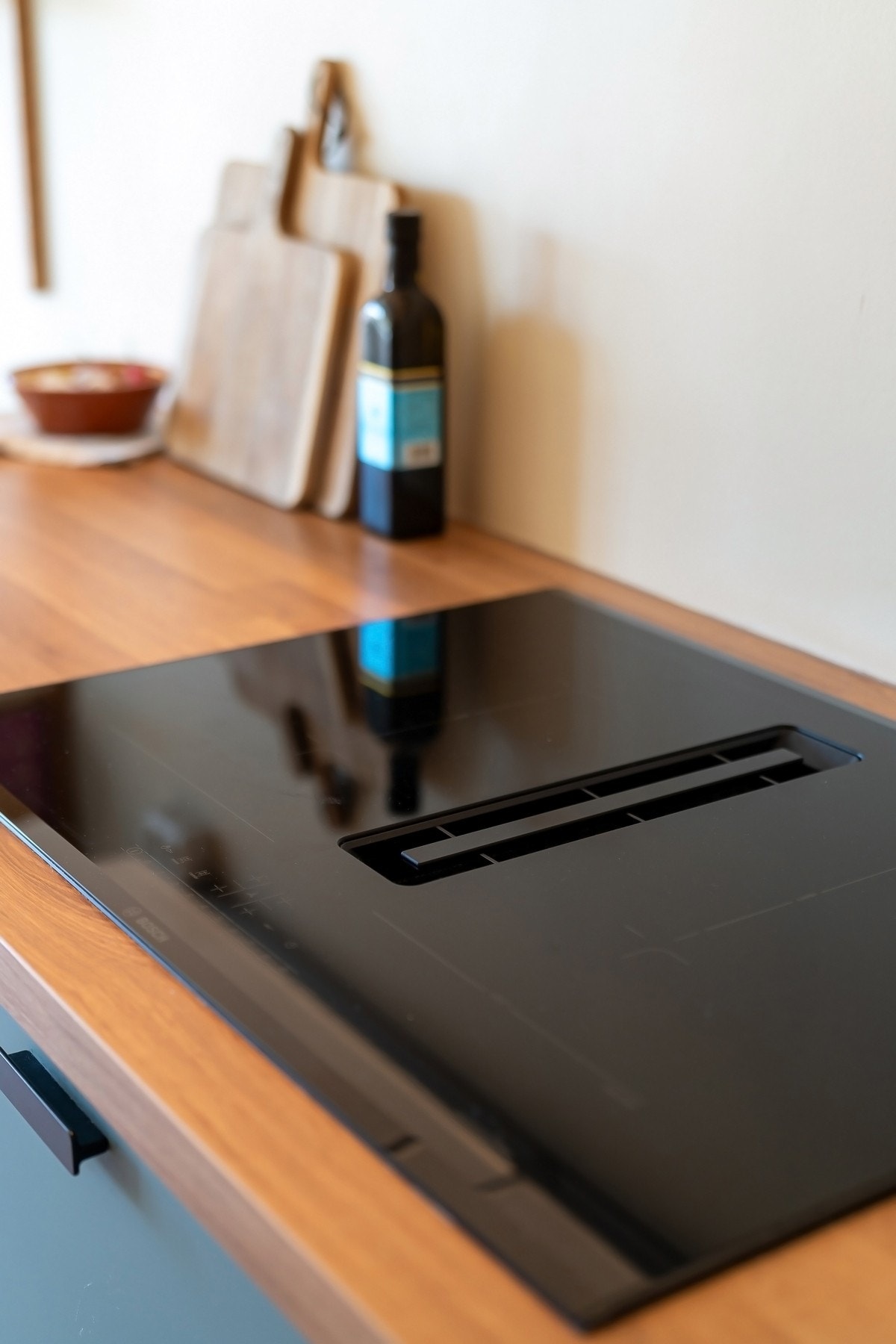 Integrerte hvitevarer som induksjonsplatetopp, stekeovn i arbeidsvennlig høyde, oppvaskmaskin og kjøl/frys. Galleribilde