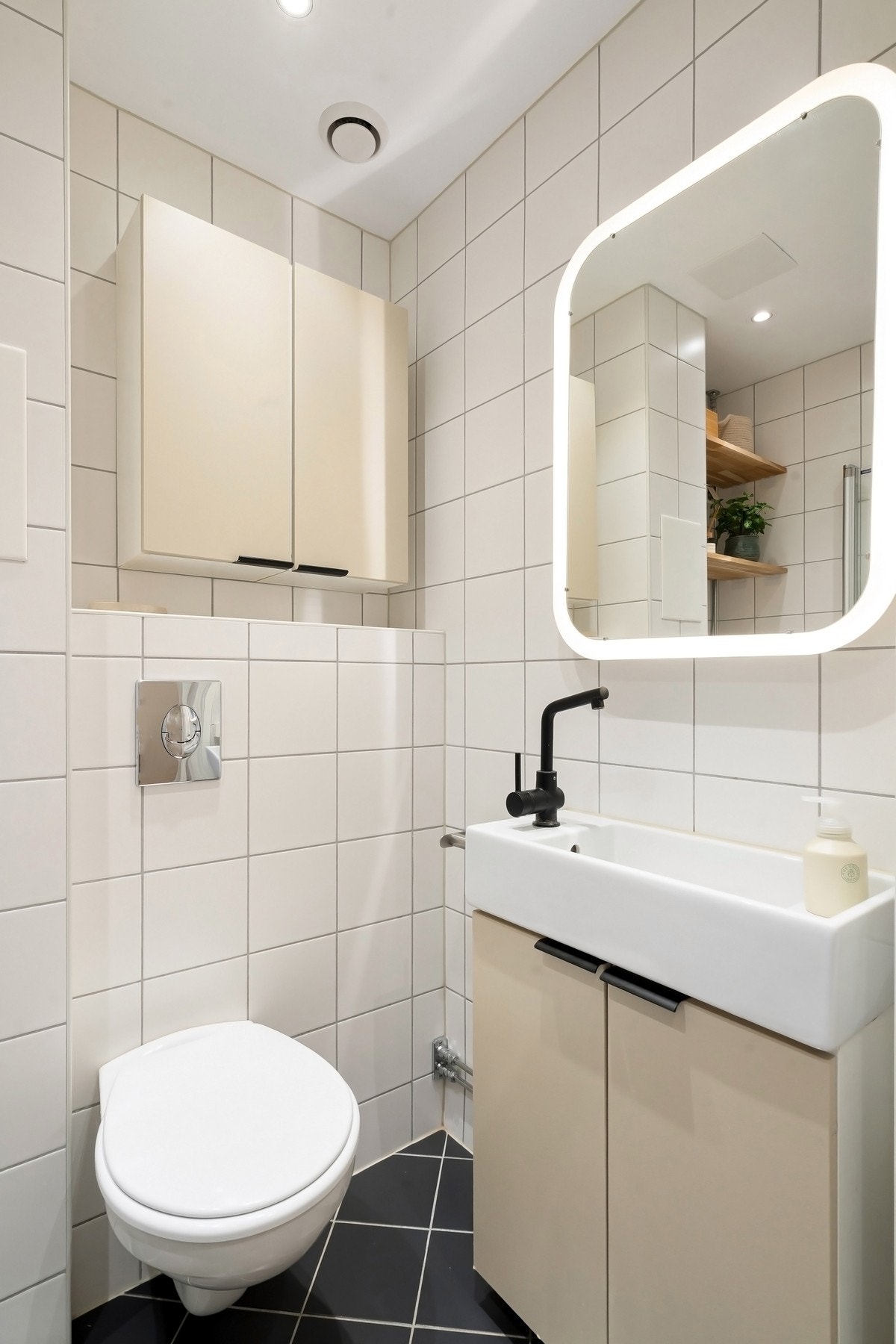 Baderomsinnredning med heldekkende servant i porsel og vegghengt speil med belysning. Galleribilde