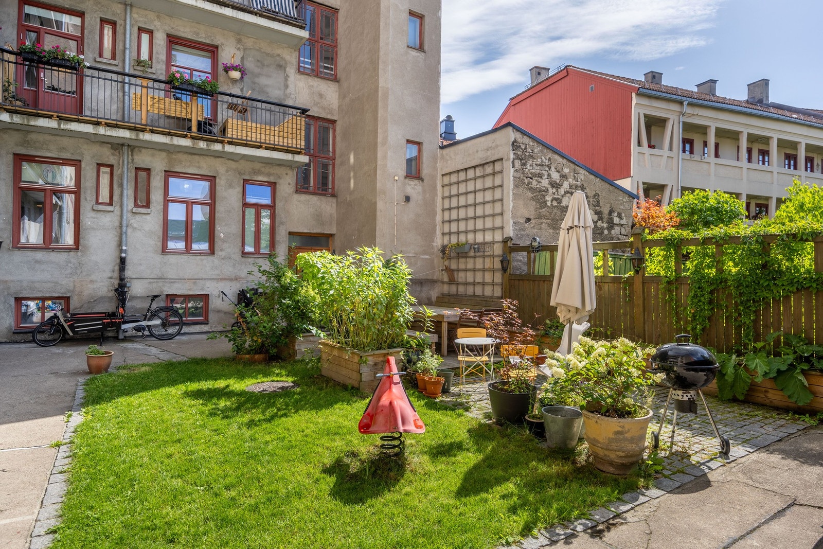 Hyggelig felles bakgård med sittegrupper og sykkelparkering med tak og stativer. Galleribilde