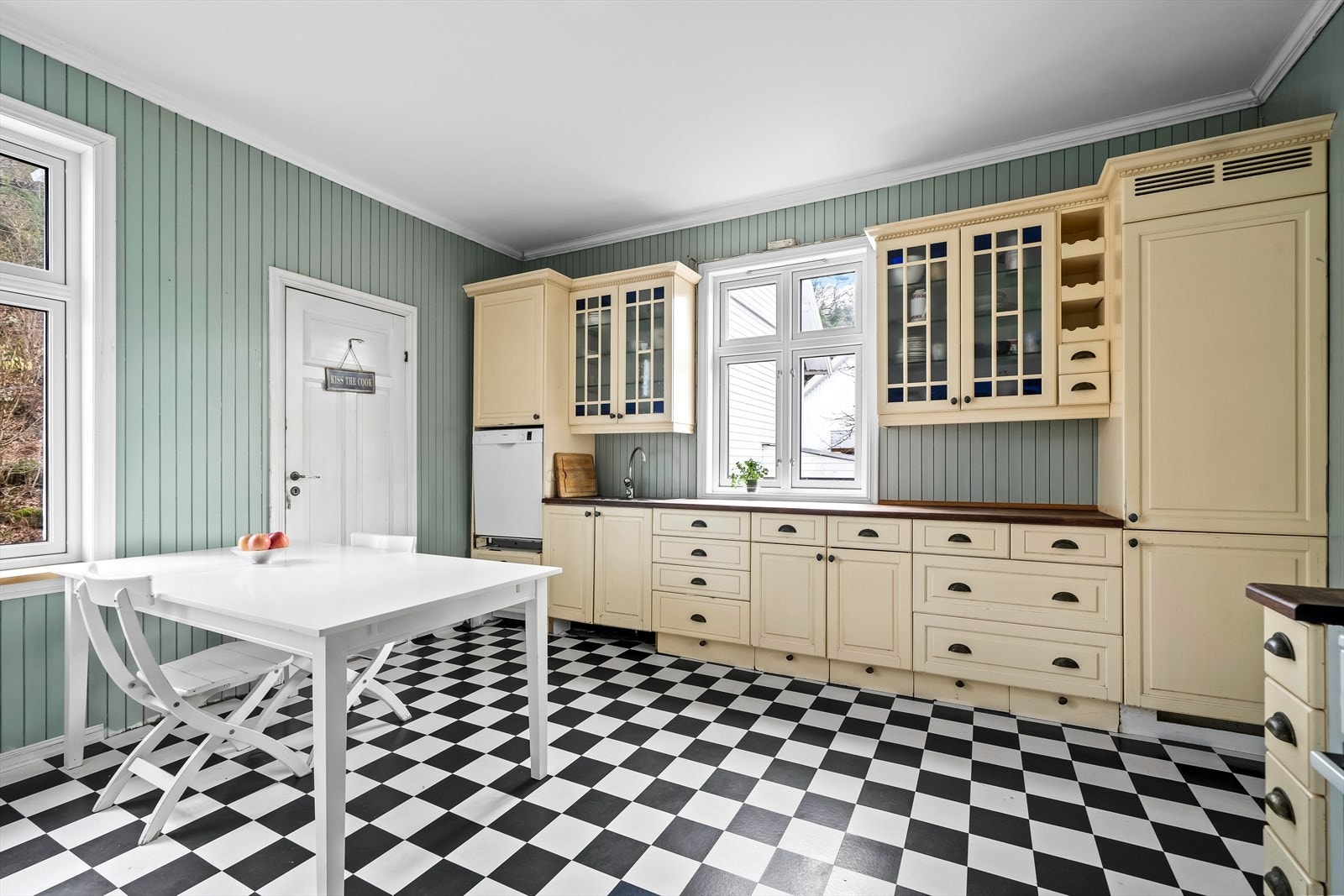 Trivelig kjøkken med smalpanel på vegg og sjakkmønstret gulv. Profilert innredning med overskap med glass. Oppvaskmaskin medfølger. Galleribilde