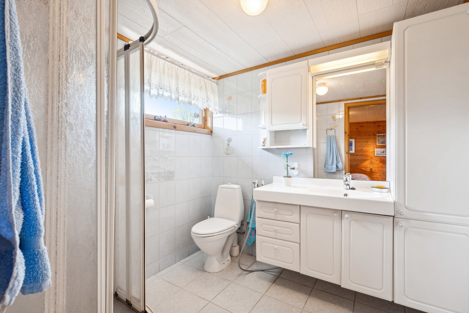 Badet i annekset har flislagt gulv, dusjnisje, toalett og en baderomsinnredning som gir god plass til oppbevaring av håndklær og hygieneartikler. Galleribilde