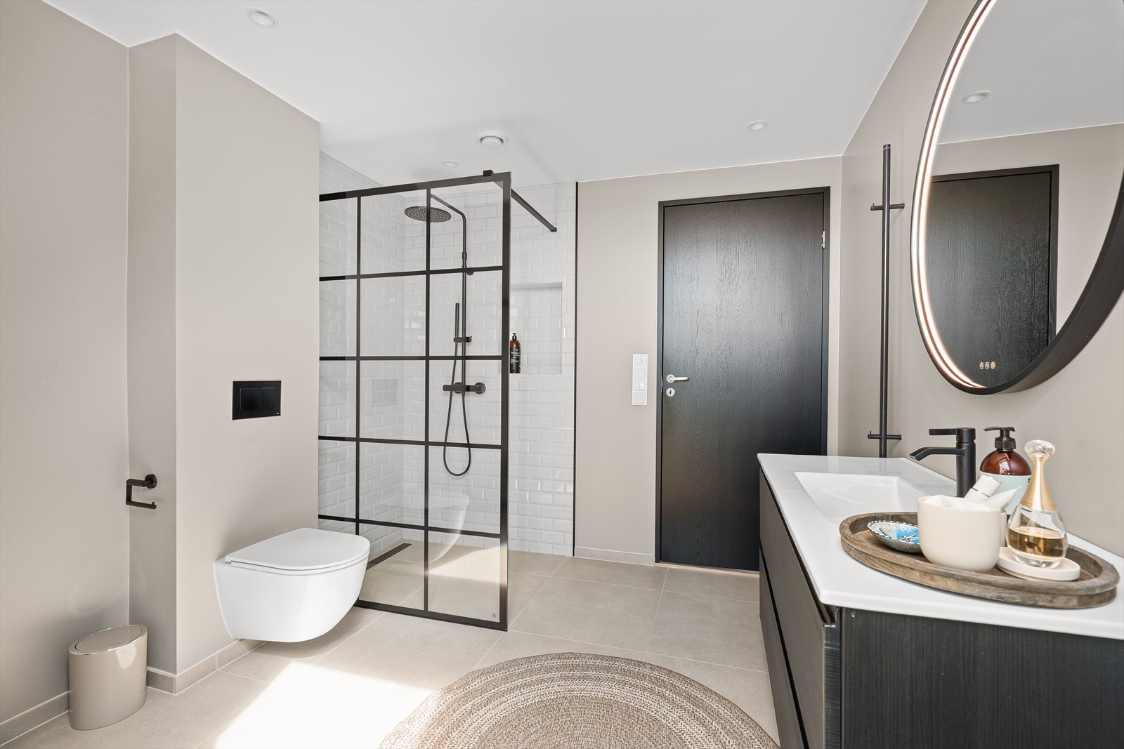 Badet består av en dusjnisje med regndusj og hylle til såpeartikler, vegghengt toalett, baderomsinnredning med speil over, plass til vaskemaskin/tørketrommel, samt hånklevarmer. Galleribilde