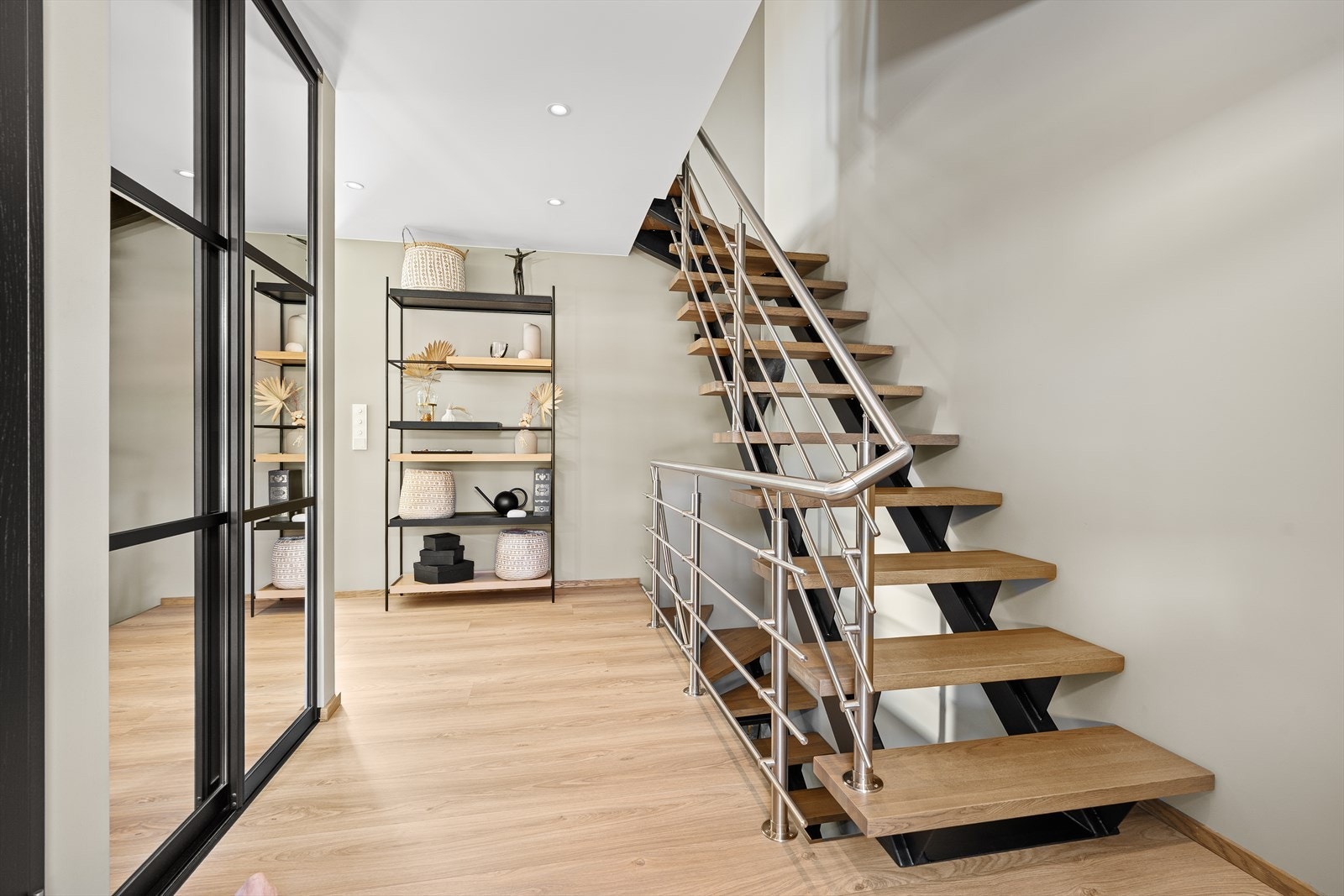 Videre inn finner du mellomgangen og entreen hvor det er gjort plass til en skyvedørsgarderobe. Legg merke til den stilige trappen som er blitt sveiset lokalt og tilført eiketrinn og rekkverk. Galleribilde