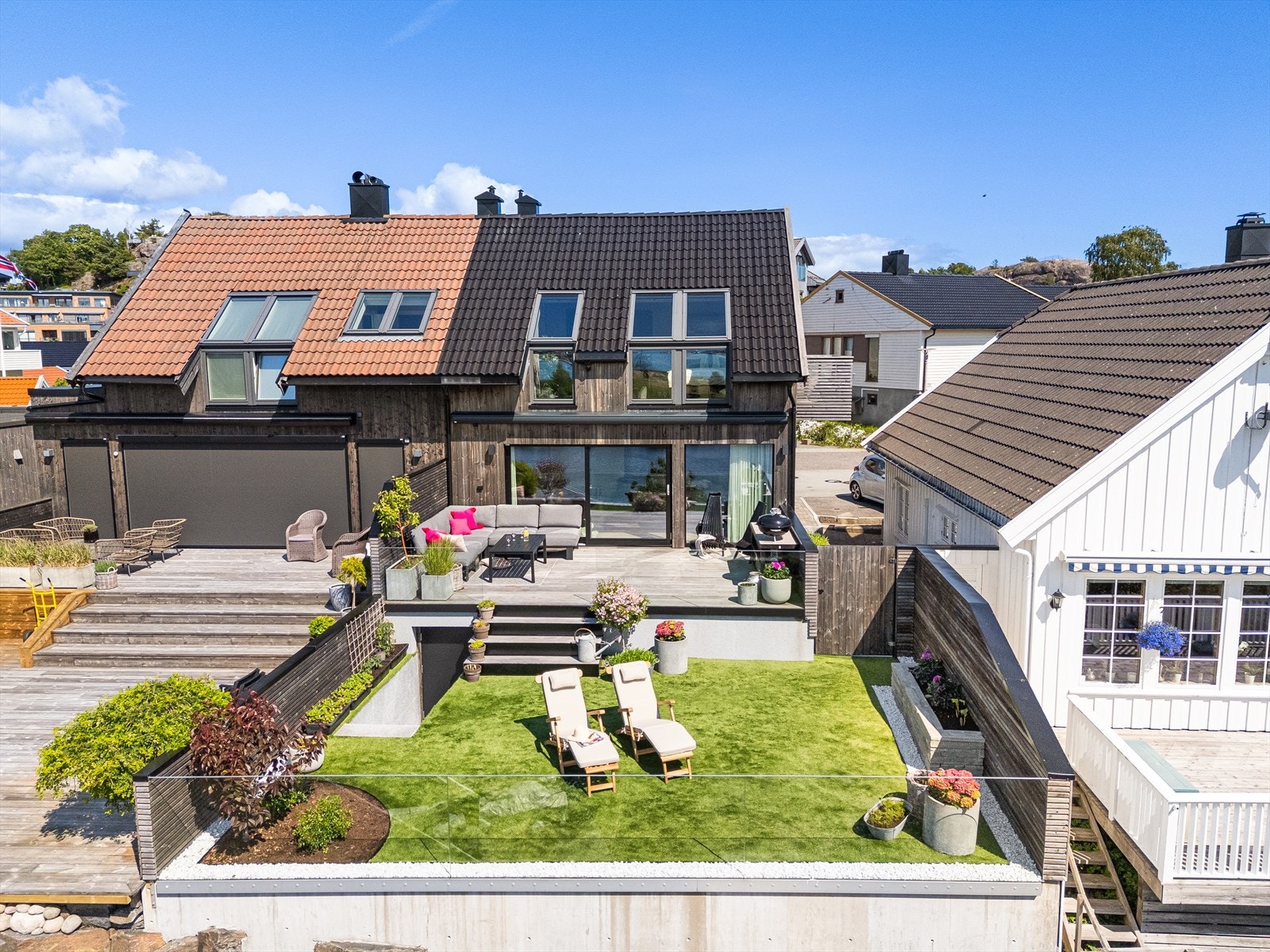 Eiendommen er vesentlig oppgradert med kebony terrassedekke, kunstgress, elvesteiner, planetbedd mm. Trapp og dør til venstre tar deg til en tørr bod under terrassedekket. Galleribilde