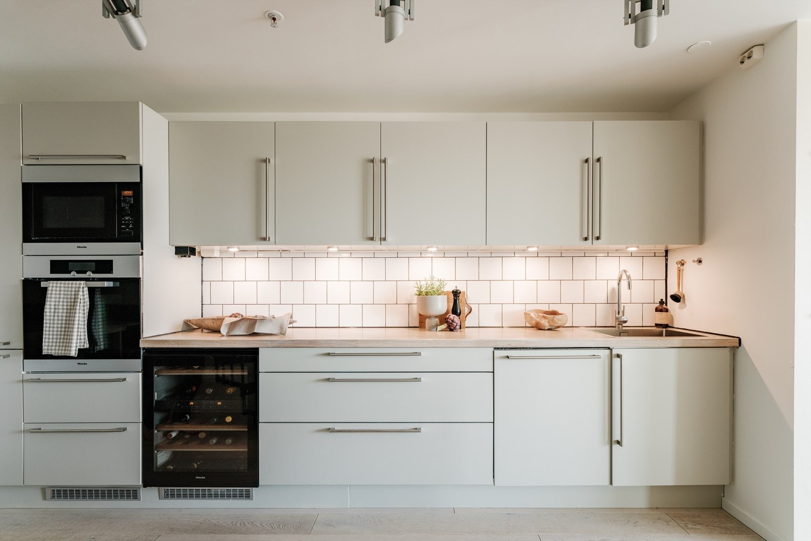 Stilrent HTH-kjøkken med komplett utvalg av integrerte hvitevarer, som mikrobølgeovn og vinskap fra Miele. Galleribilde