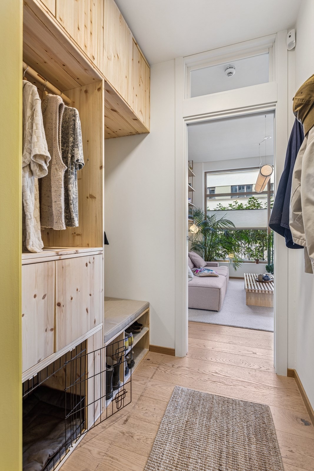 Det er plassbygget møblement i entréen med rom for både oppheng av ytterklær og å sette fra seg sko. Selgerne har også bygget inn hundebur nederst til venstre - gitteret kan enkelt kobles av for å heller benytte rommet til skooppbevaring. Galleribilde