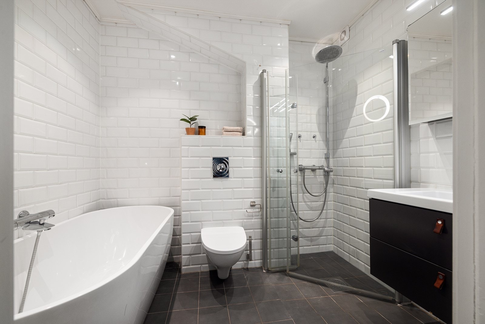 Delikat bad som ble vesentlig oppgradert i 2016. Badet har flislagte overflater med mørke gulvfliser og hvite metrofliser, behagelig gulvvarme og downlights i himling. Galleribilde