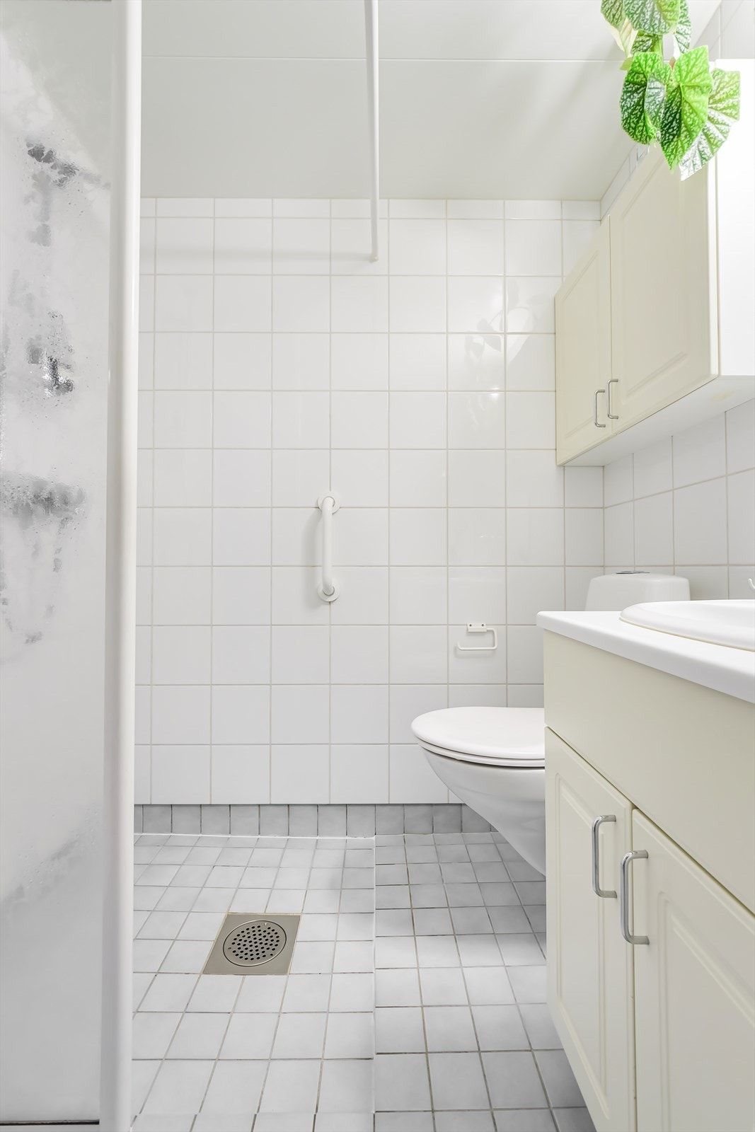 Vegghengt innredning med heldekkende servant og lyse, profilerte fronter. Galleribilde