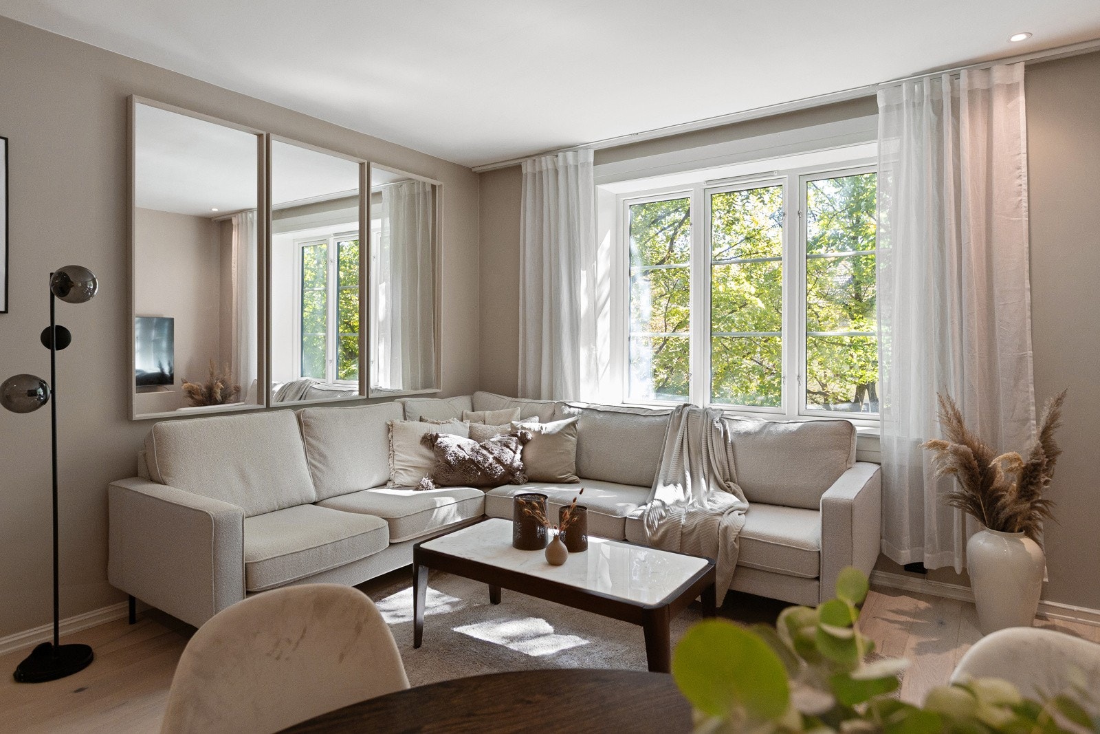 God plass til sofa og sofabord. Det er også speil på veggen som gjør leiligheten enda mer luftig. Galleribilde