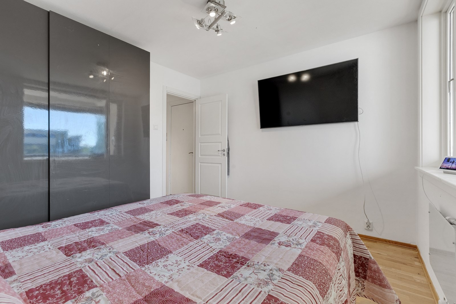 Her er det plass til stor seng og nattbord, og i tillegg har rommet en moderne skyvedørsgarderobe med høyglansfronter som gir rikelig med oppbevaringsplass. Galleribilde